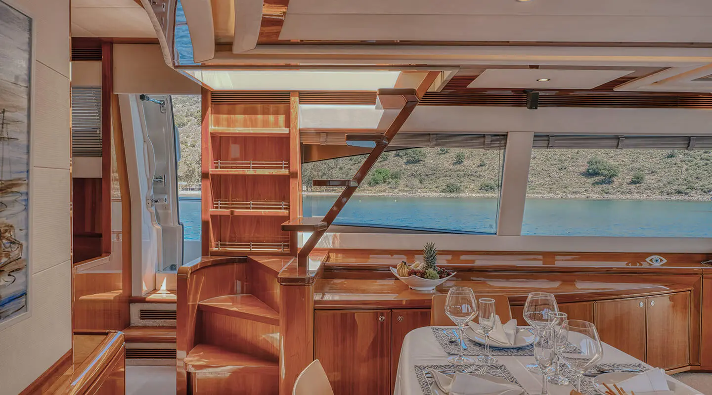 Interior of Lidia motor yacht with wooden furniture and tables visible.