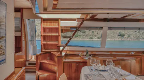 Interior of Lidia motor yacht with wooden furniture and tables visible.