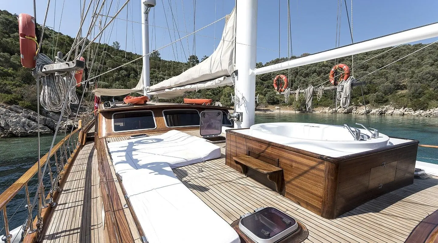 Grace 1 yacht deck with white sun loungers and polished wooden rails at sunset