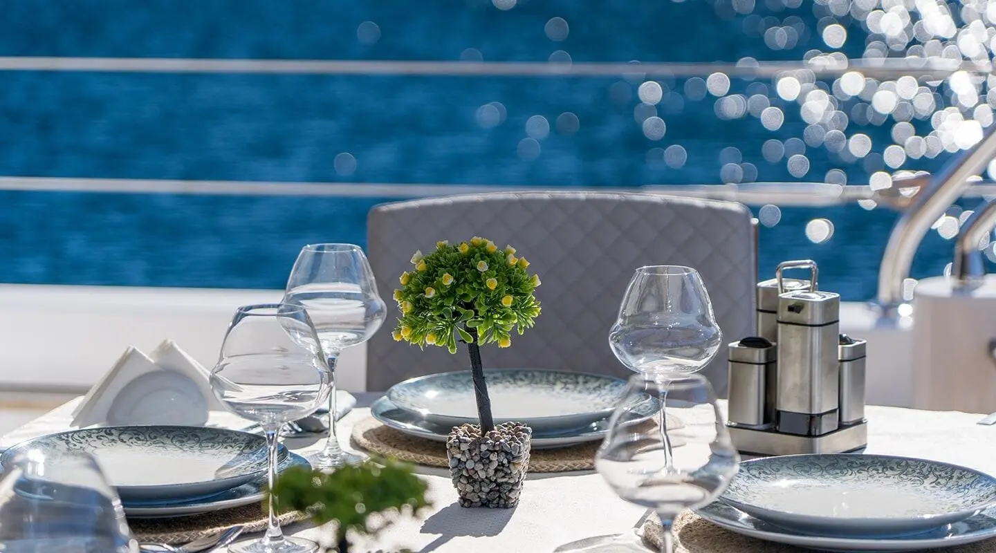 Yacht Long Island table setting with white linens and glasses on deck
