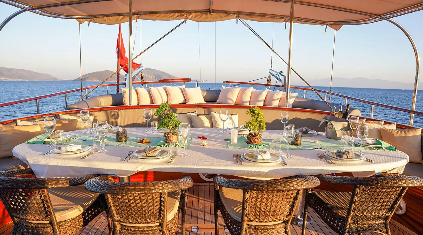 La Bella Vita yacht dining area aboard a luxury gulet at sunset with table setting