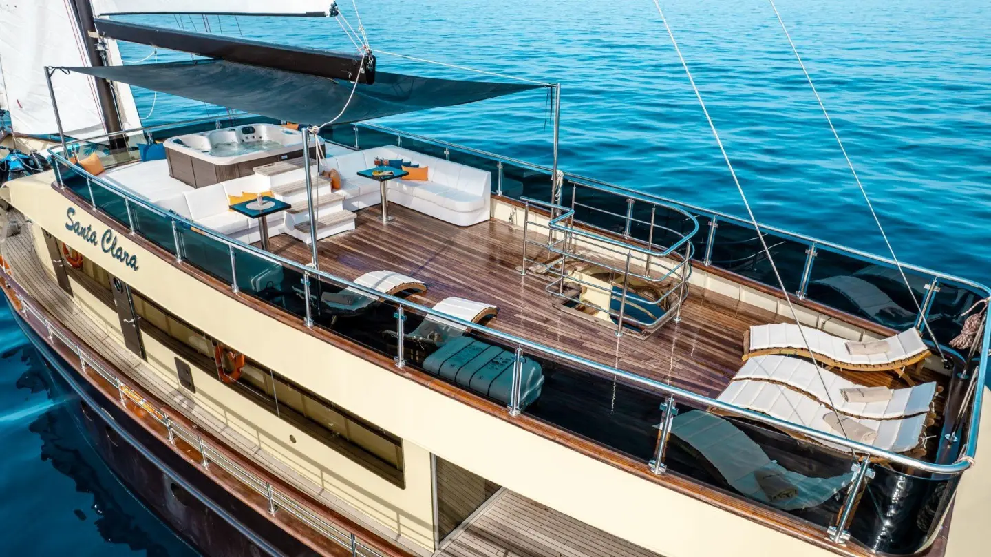 A luxury motor yacht named Santa Clara with deck seating and rigging by blue sea