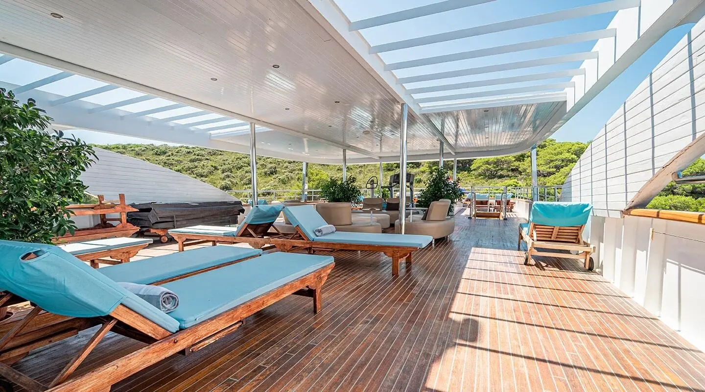 Deck seating on a luxury yacht under a shaded canopy with blue cushions