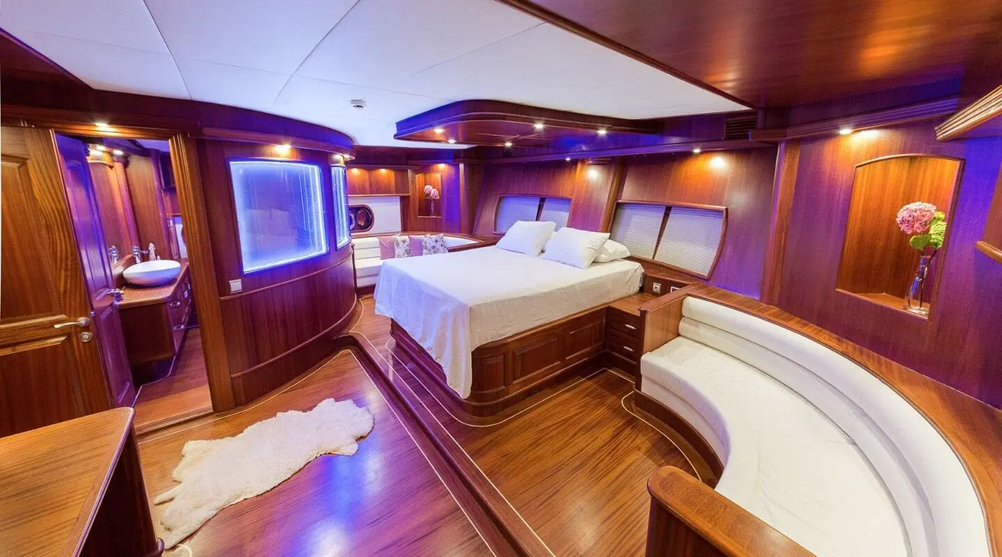 Halcon Del Mar yacht interior with two beds, warm lighting, and wooden deck