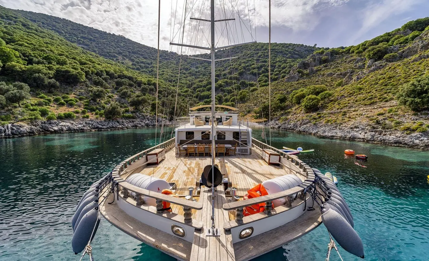 Gulet Tersane 8 viewed from bow, sails down, anchored in calm turquoise cove