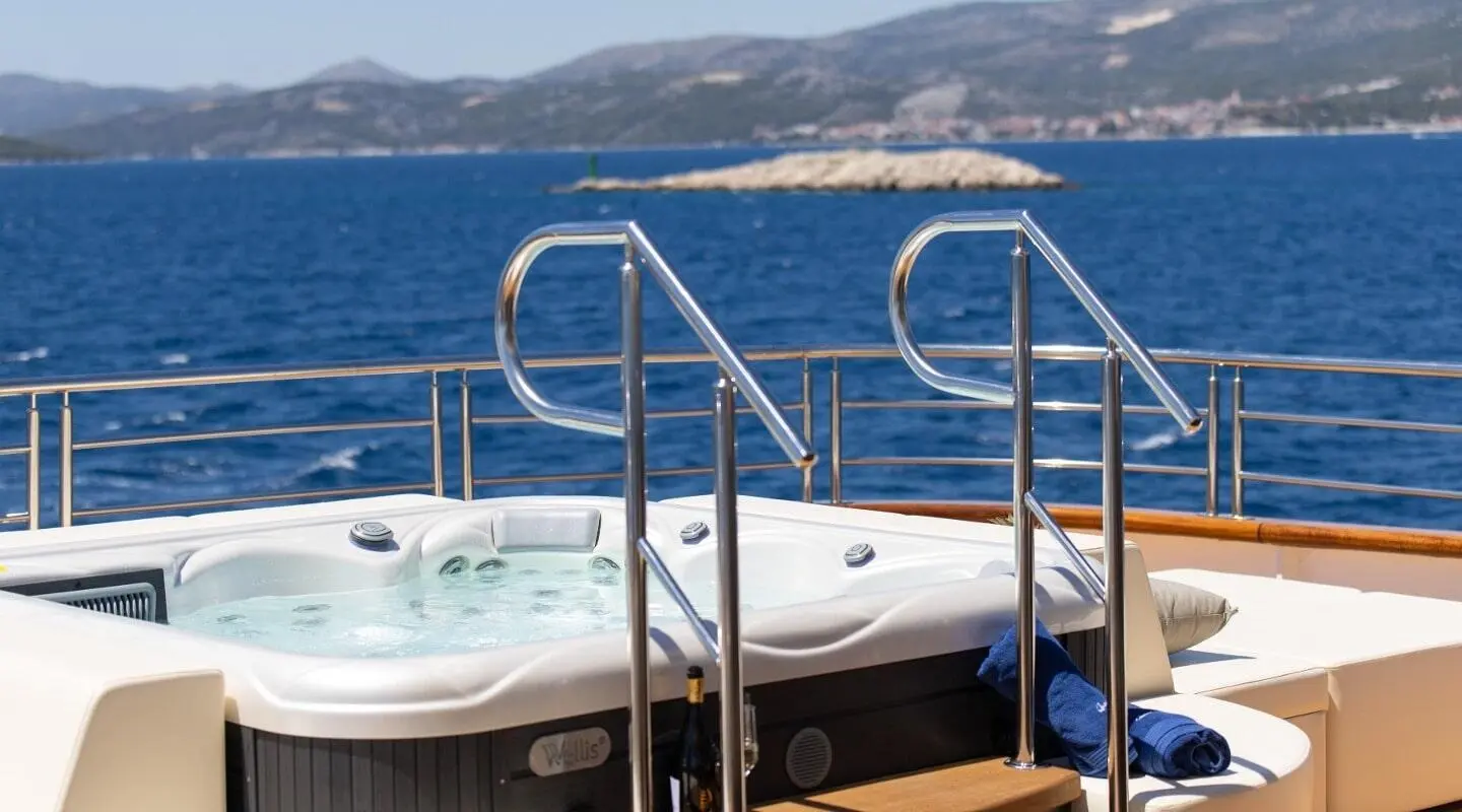 Queen Eleganza yacht's sundeck with stainless rails and water backdrop