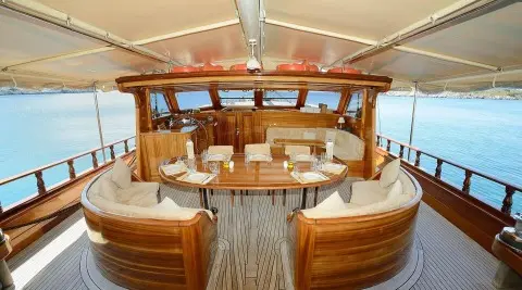 Zephyria II yacht outdoors on calm sea with wooden deck dining area under cover