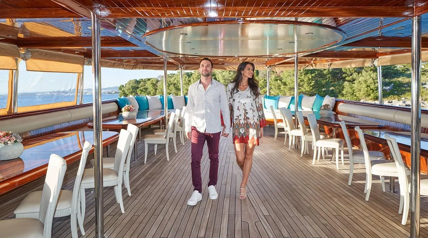 Casablanca yacht deck at sunset with couple walking along teak flooring