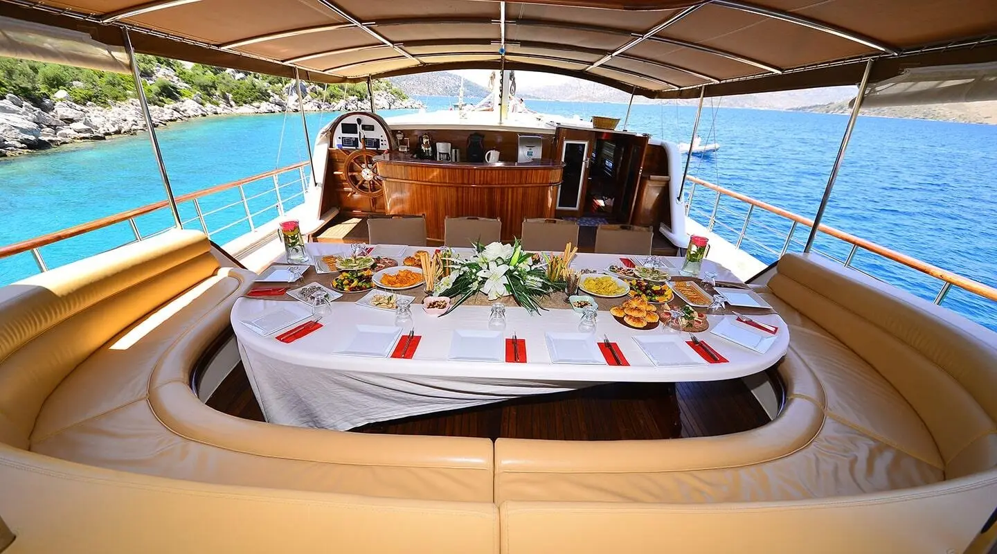 Prenses Bugce yacht dining aboard a gulet at sunset on deck table setup