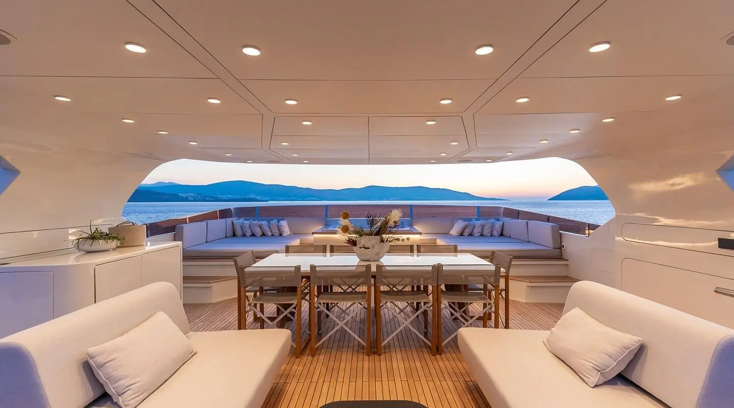 Illusion II yacht lounge with seating and tables and open sea view