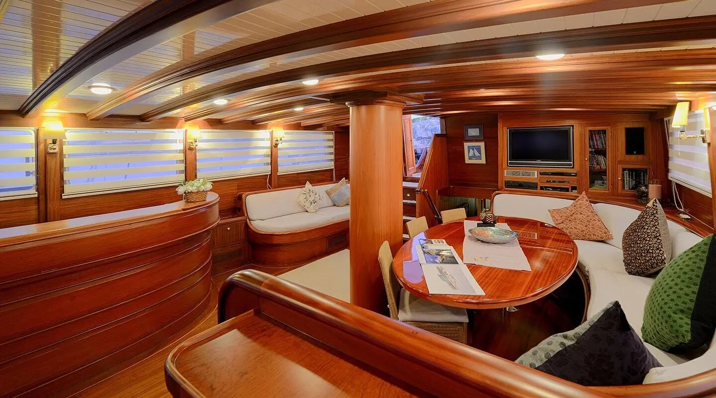 Interior view of Ecce Navigo gulet saloon with wooden cabinetry and seating