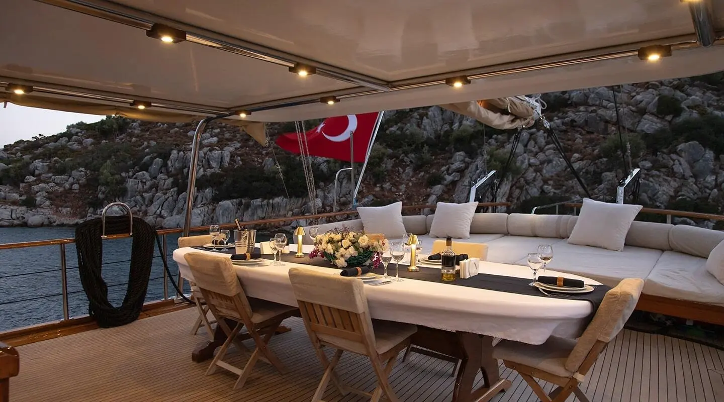 Derin Deniz yacht deck dining scene at sunset with tableware and seating