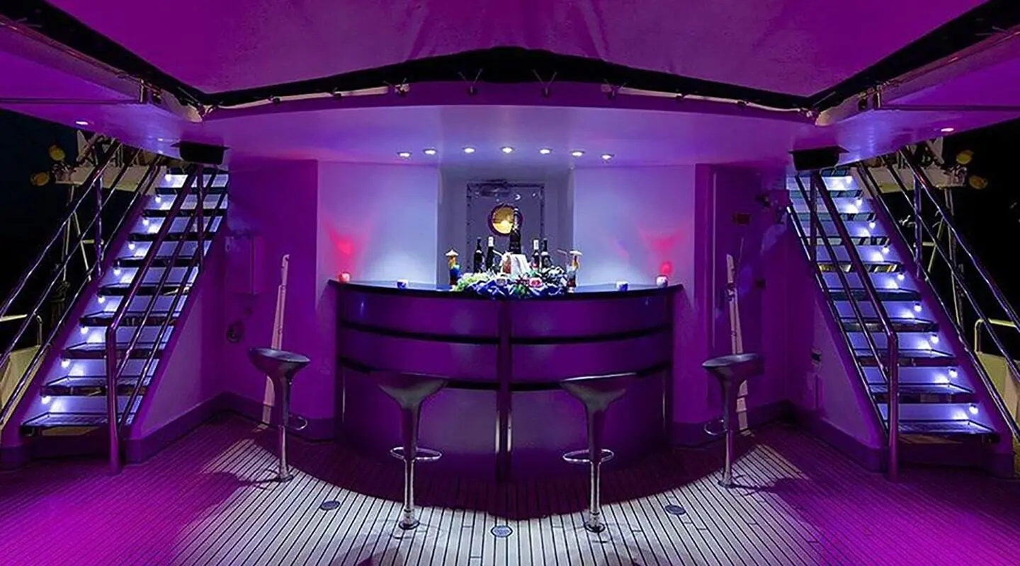 Running on Waves interior bar area with purple lighting and two staircases on either side
