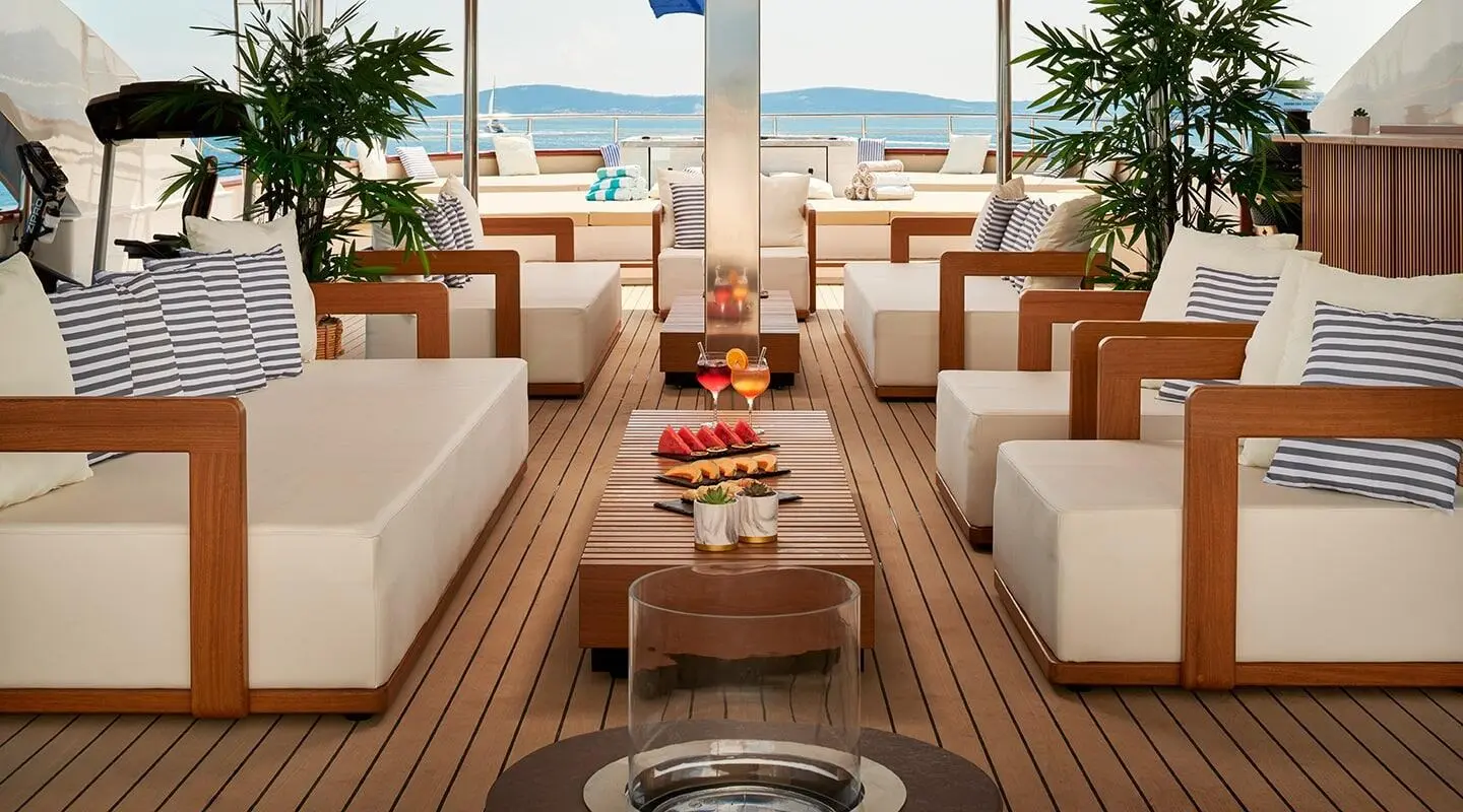 Ohana yacht sun deck with seating, tables, and ocean view at sunset