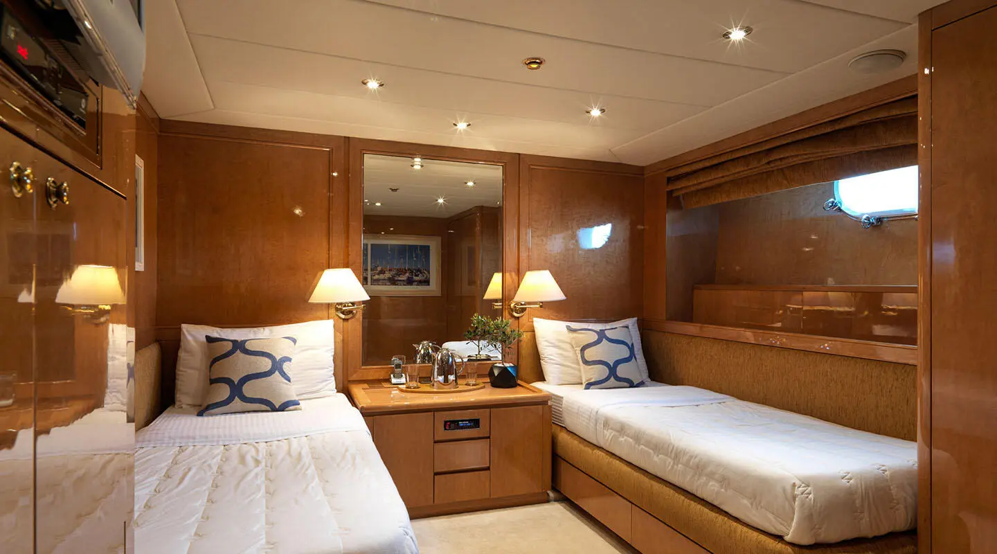 Cozy yacht cabin with two cushioned berths and wood paneling on Idylle
