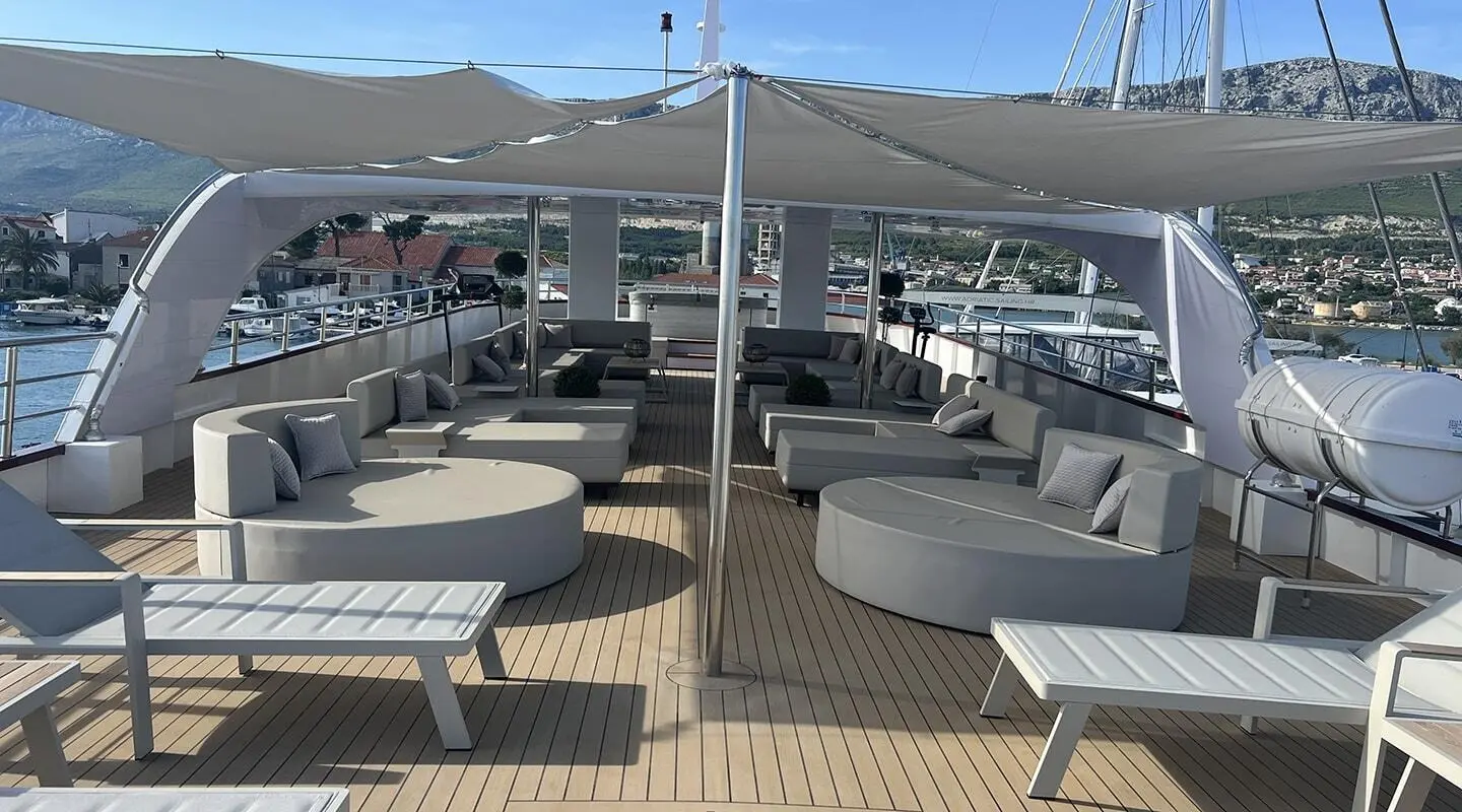 Melody yacht sun deck with lounge chairs and tables visible