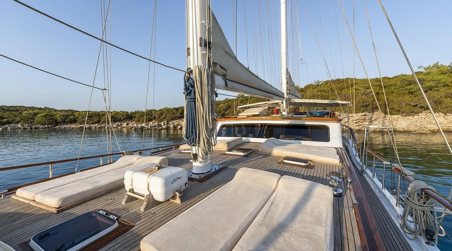 Gulet Artemis sun deck with seating, ropes, and sails on calm sea day