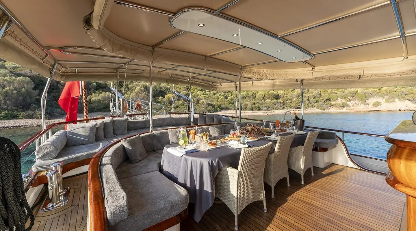 Gozdem The One yacht charter interior deck with arranged seating under a shaded canopy