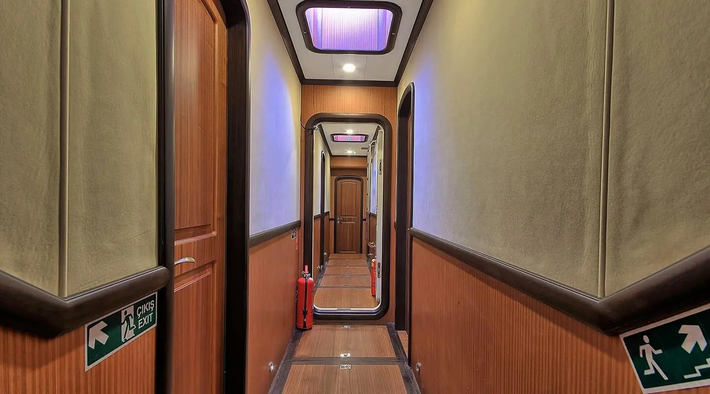 Queen Of Salmakis yacht interior hallway with wooden panels and deck lighting