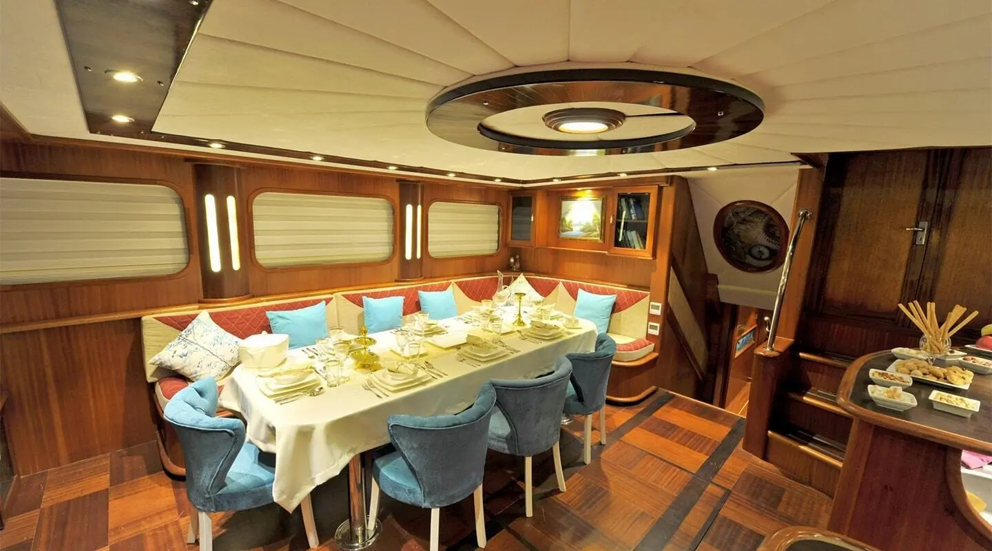 Interior dining area aboard Berrak Su yacht with table set for guests
