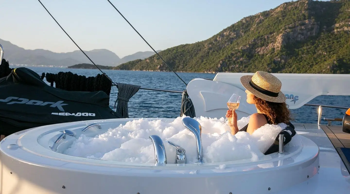 Yacht 'Good Life' with white deck and passengers relaxing at sunset