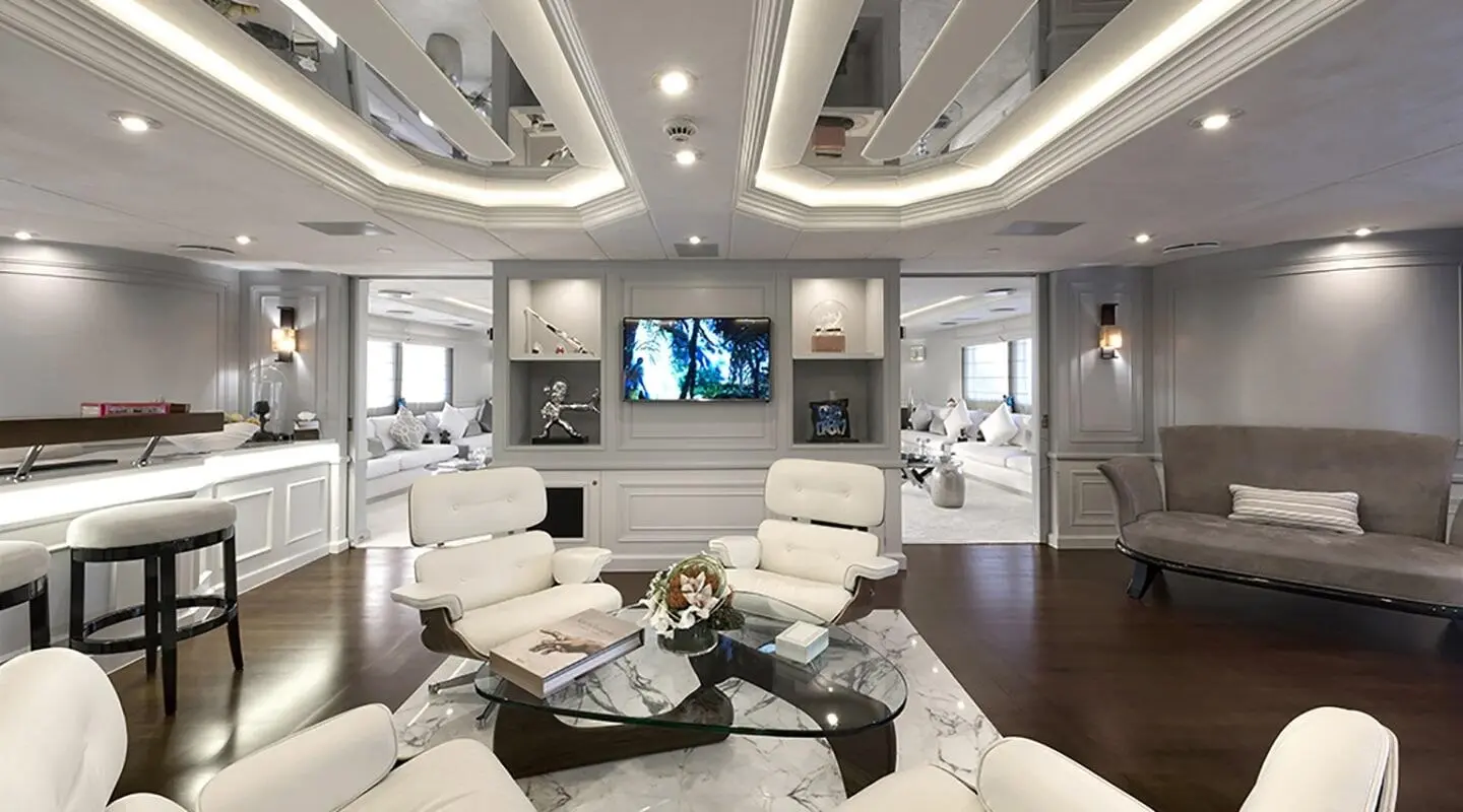 Chakra yacht lounge with cream leather seating, coffee table, and built-in TV screens