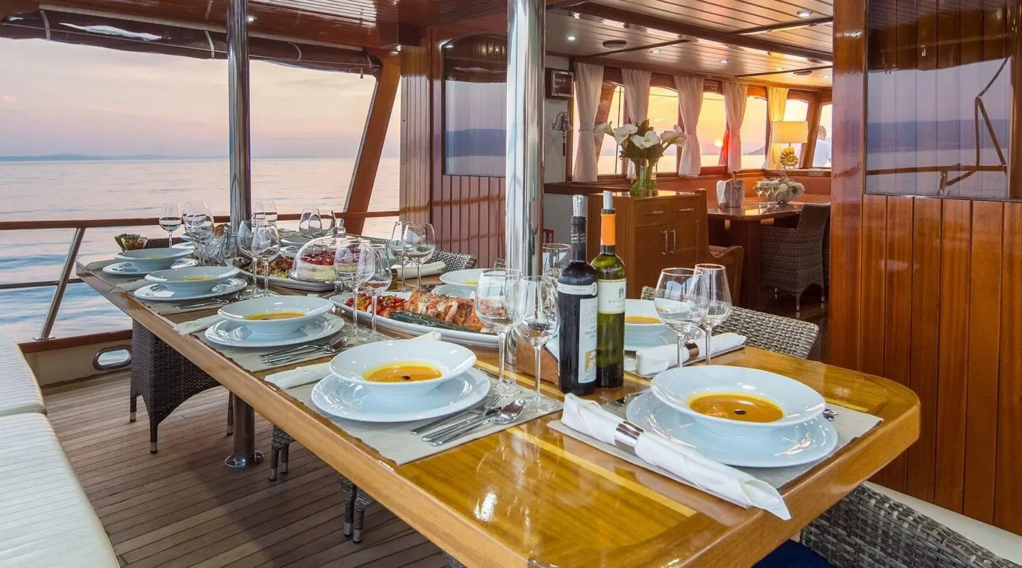 Yacht Altair dining aboard a luxury gulet at sunset on deck with table setting