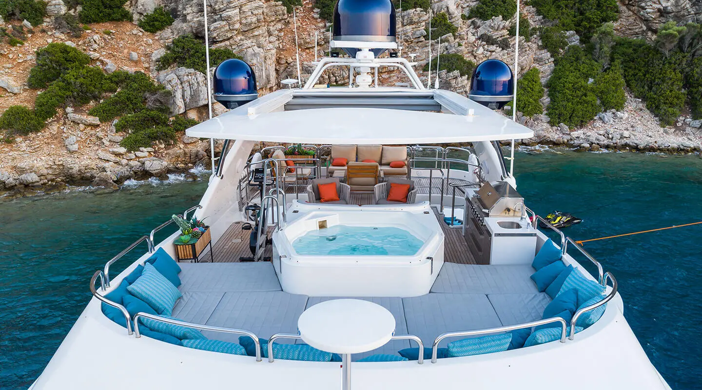 Amadea yacht exterior with sunlit flybridge, seating, and blue water backdrop