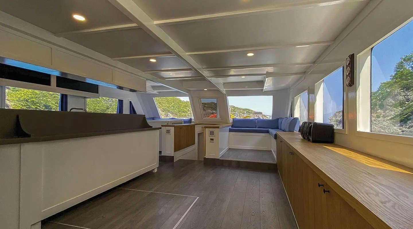 Maske 5 yacht interior with seating and windows to blue water sunset view