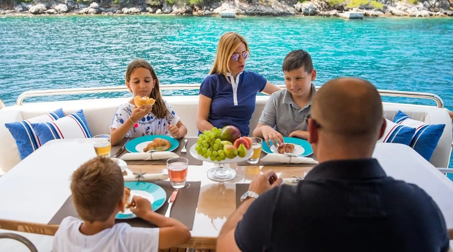 Salt yacht dining group having breakfast at a table by the sea