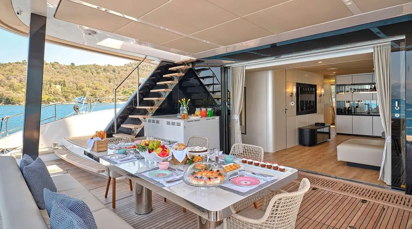 Genny gulet aft deck table set for dining with stairs and shaded canopy
