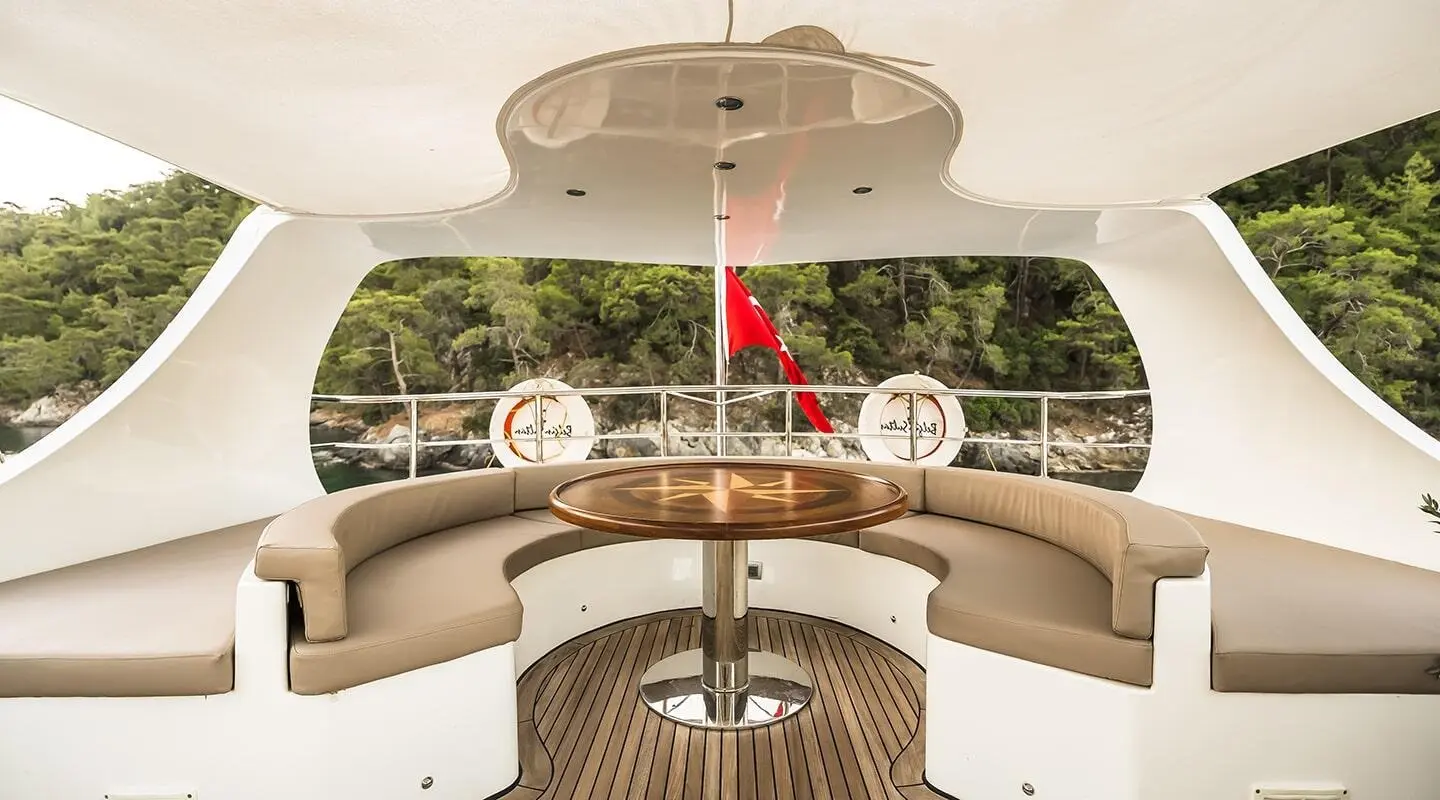 Belgin Sultan yacht deck lounge with curved seating and sunset-lit horizon