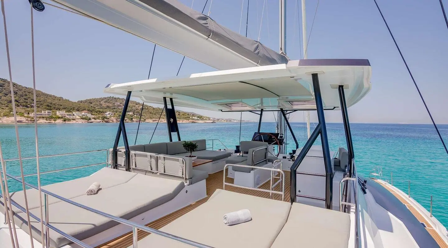Astoria yacht deck at sunset with seating, rails, and blue water view