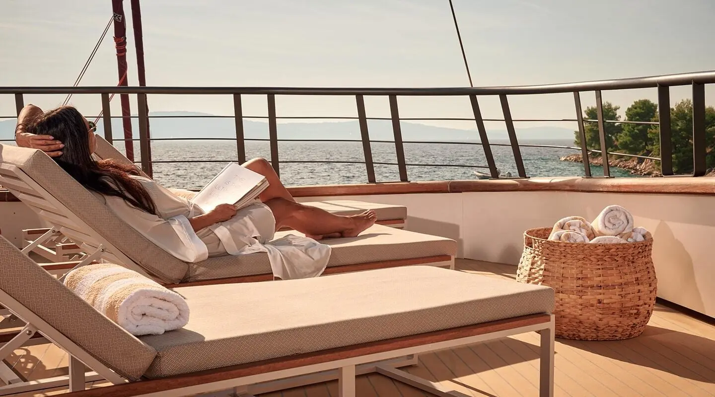 Anetta yacht deck with sun loungers and railing by the sea horizon