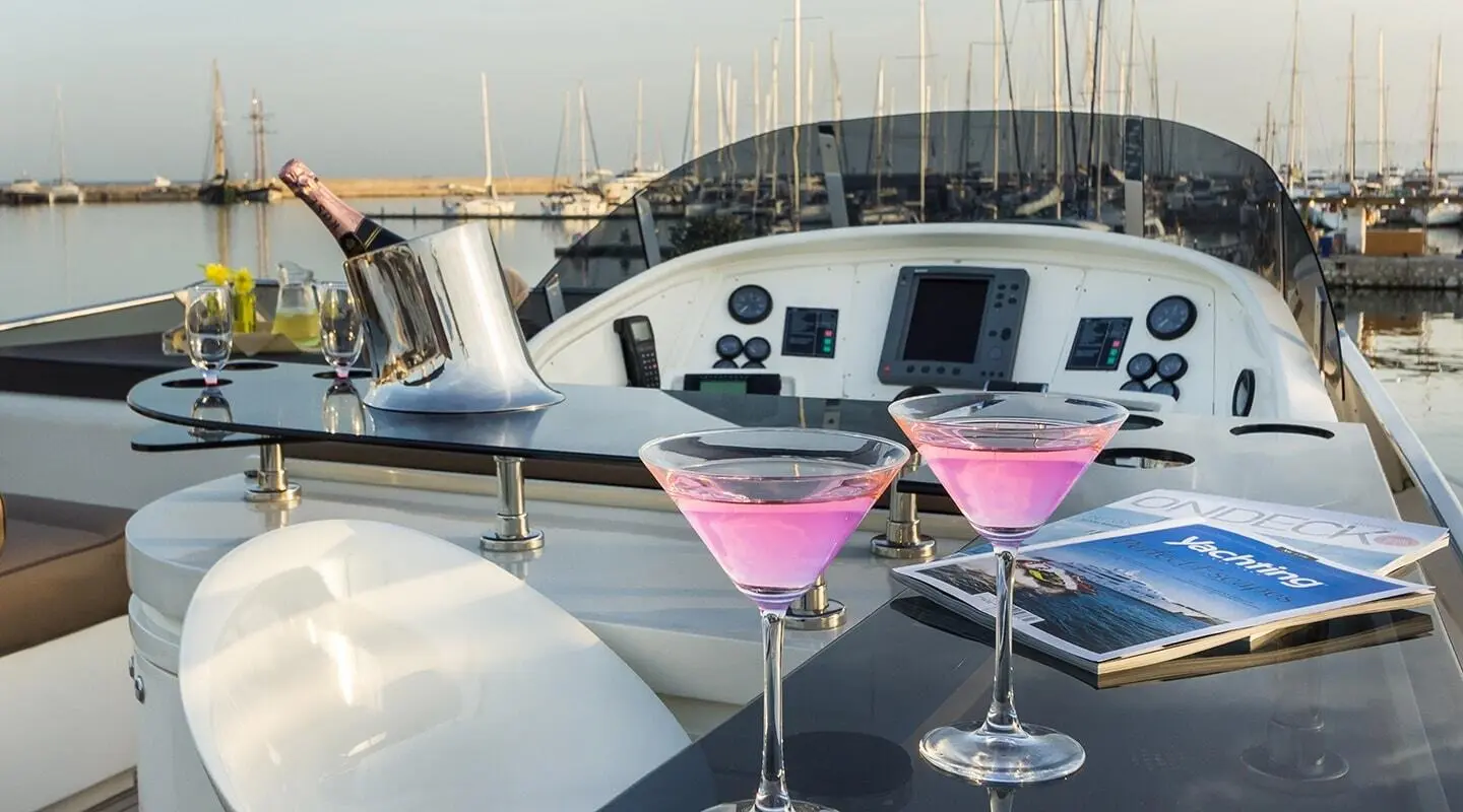 Amoraki motor yacht deck scene with two pink cocktails on a table