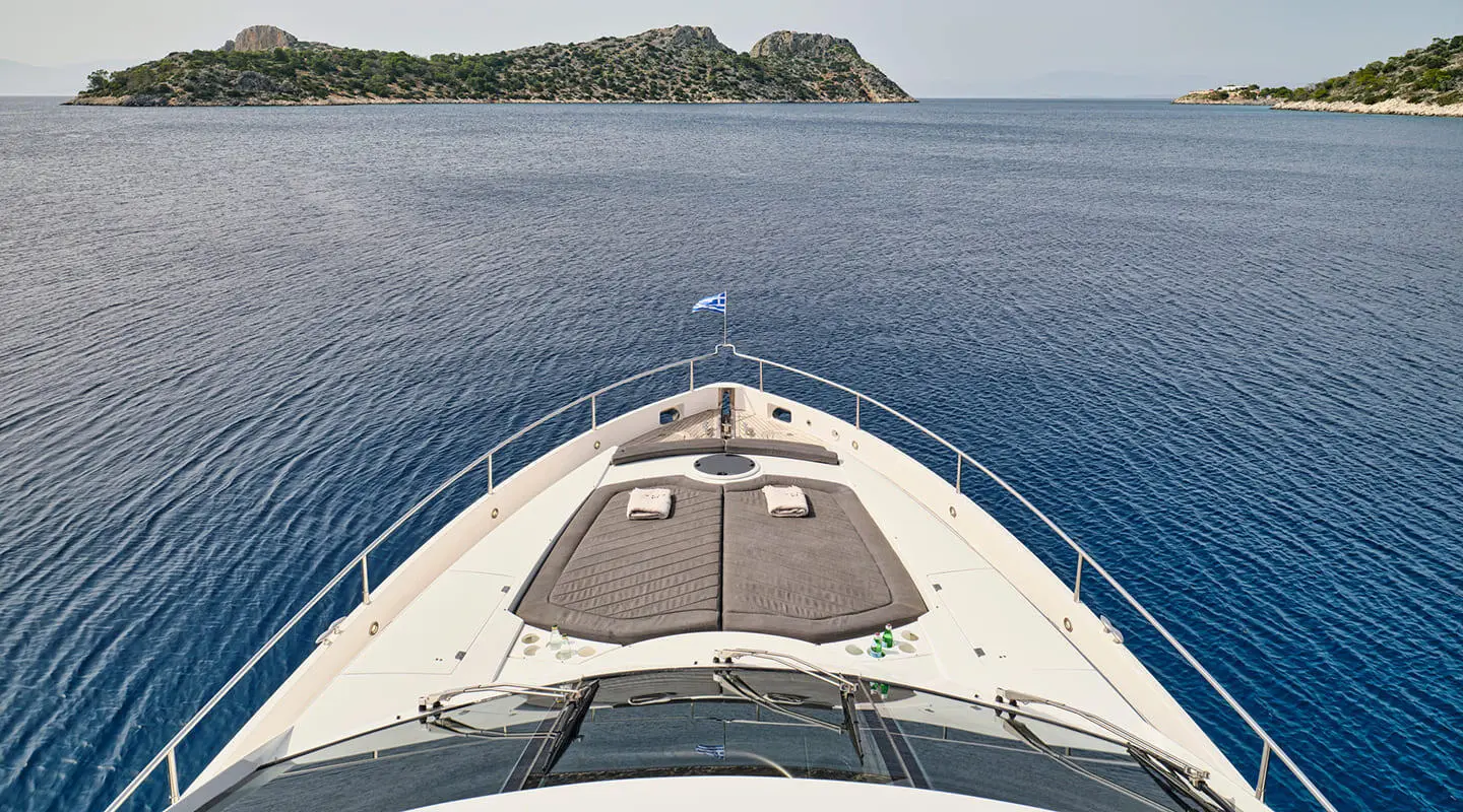A luxury forward bow area of M Five yacht with sunbeds and blue sea