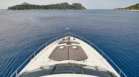 A luxury forward bow area of M Five yacht with sunbeds and blue sea