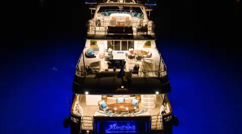 Amadea luxury yacht at night, illuminated decks and stacked hulls in blue water