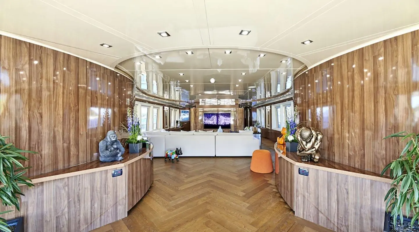 Daloli yacht interior salon with curved seating, wooden cabinetry, and panoramic windows