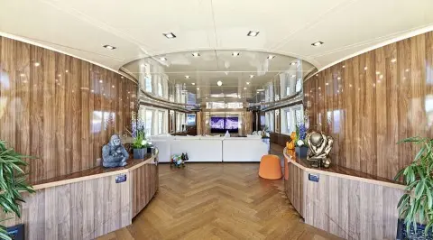 Daloli yacht interior salon with curved seating, wooden cabinetry, and panoramic windows