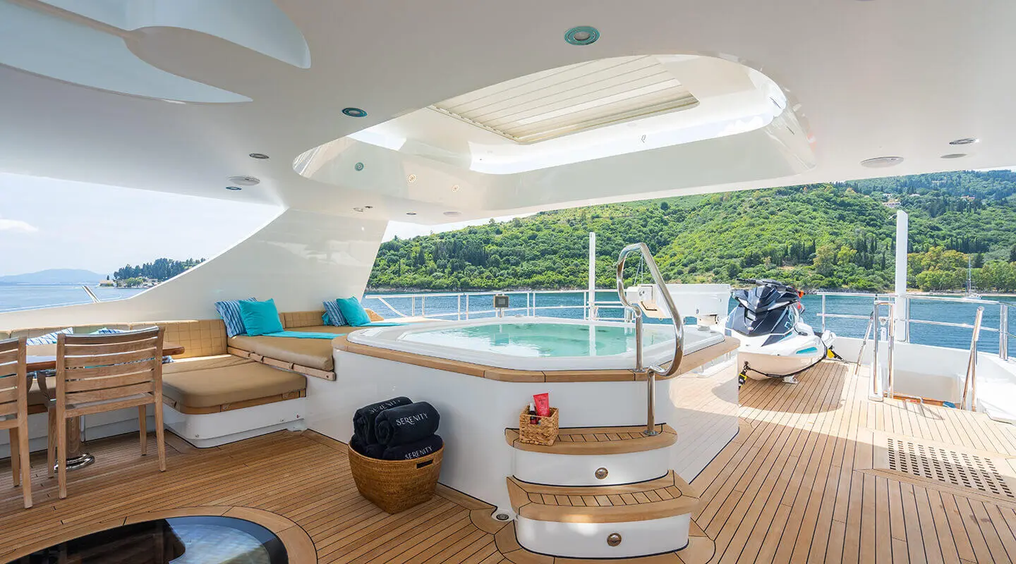 Serenity yacht deck with hot tub and seating area under a shaded upper deck