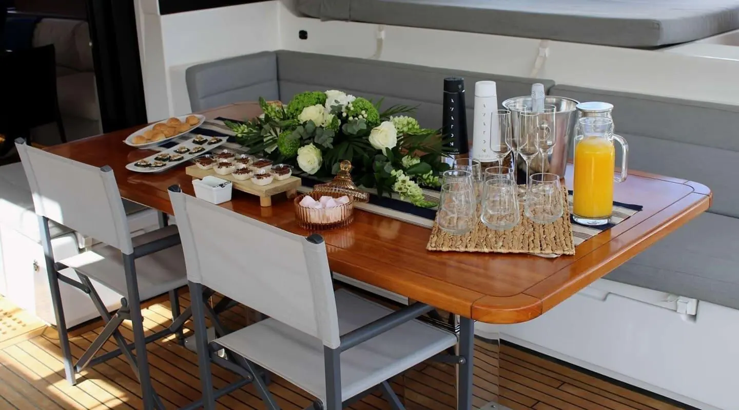 Atlantis luxury yacht dining table setup with cocktails, flowers, and appetizers onboard