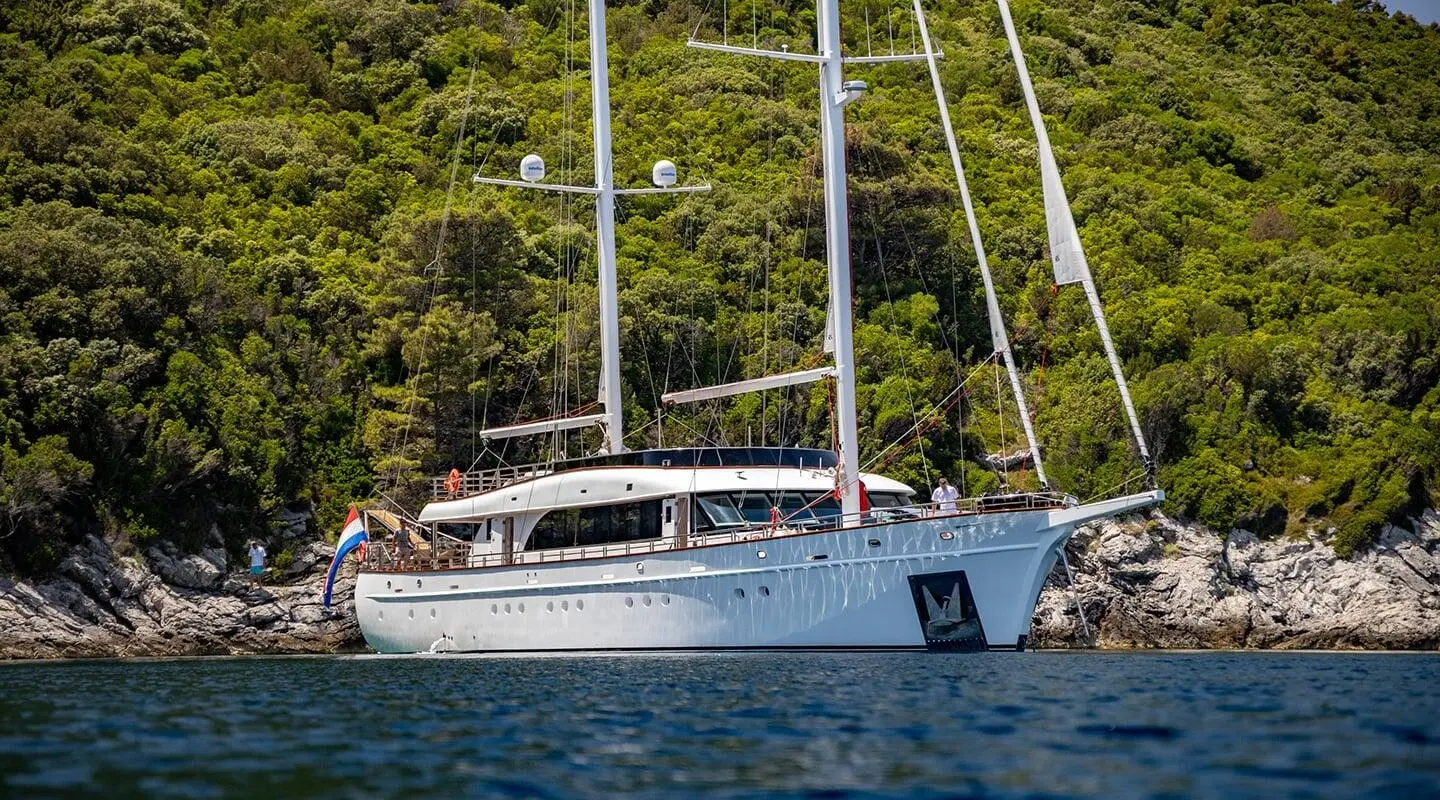 Blue yacht Love Story seen from side near shoreline