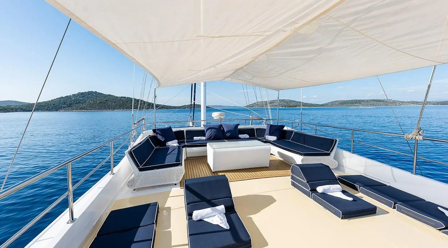 Aurum yacht deck with beige seating and blue cushions overlooking blue sea