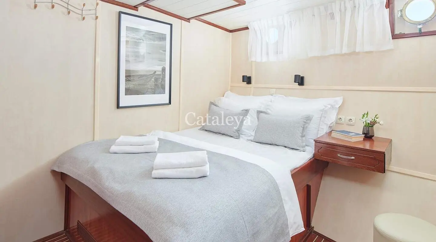 Luxurious white bed with pillows in a yacht cabin, soft lighting