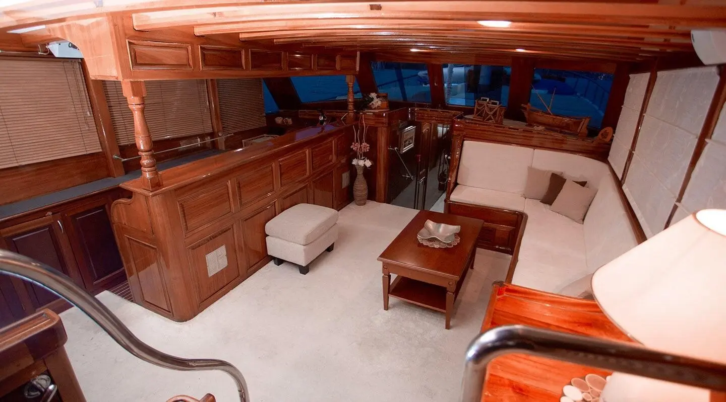 Luxurious 26m yacht interior lounge with polished wood paneling and cream upholstery