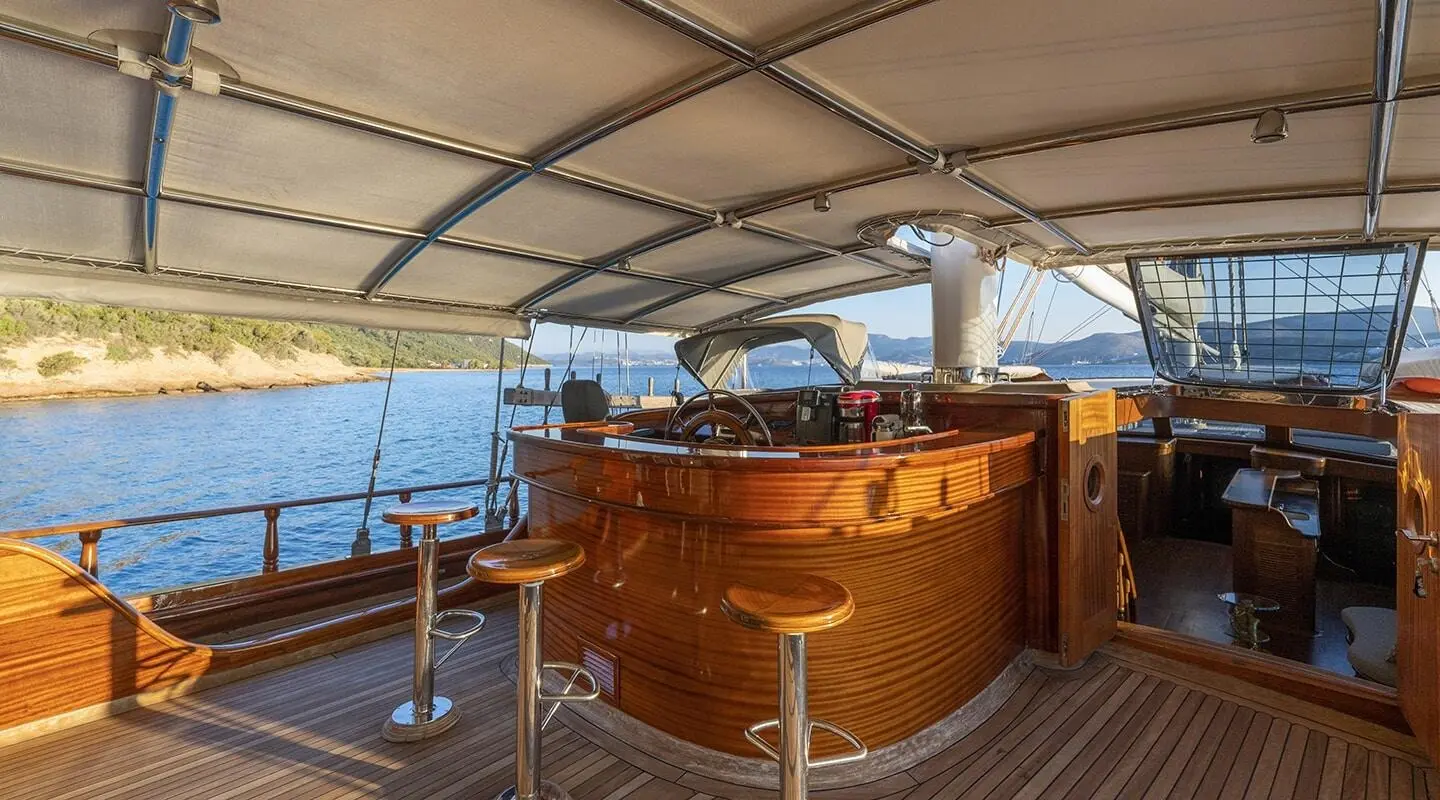 Yacht Bedia Sultan on calm sea, polished wooden deck, seating area under canopy