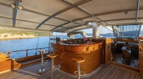 Yacht Bedia Sultan on calm sea, polished wooden deck, seating area under canopy