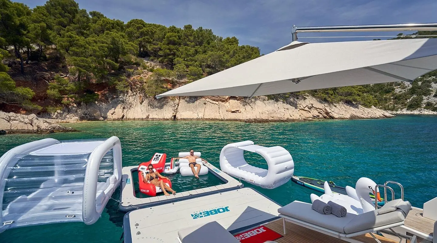 Aluminia Too yacht deck with seating, sun shade, and turquoise sea backdrop