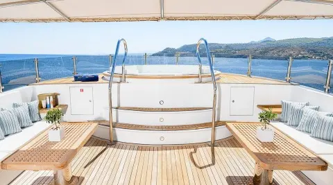View from yacht Wind Of Fortune deck toward blue sea, beige railing, and distant coastline
